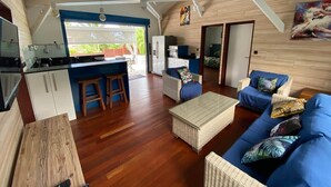 A spacious living area with a kitchen, a dining table, and a blue sofa set.