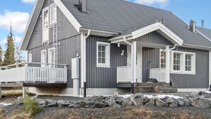 A two-story house with a grey exterior, white trim, and a covered porch. - Iso-karpalo a by Interhome (Kuusamo)