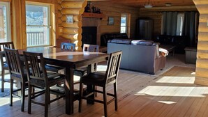 A log cabin interior with a dining area, kitchen, and living space. - Secluded luxury lodge that sleeps 34 in beds (Price)