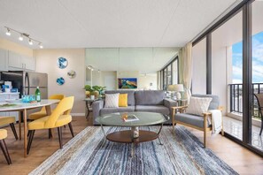 Uma sala de estar moderna com uma mesa de centro de vidro, um sofá e cadeiras amarelas.