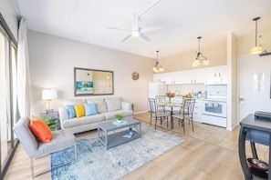A modern living room with a sofa, coffee table, and dining area.