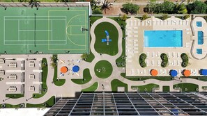 An aerial view of a hotel with a tennis court, swimming pool, and outdoor seating areas. - Sky-high condo w/ lanai & beach access (Honolulu)