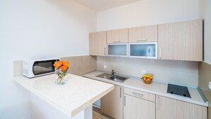 A modern kitchen with a microwave, sink, and a small fruit bowl. - Apartment Blue Chill- Comfort Studio Apartment (Mlini)