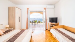 A bedroom with two beds, a TV, and a view of the sea. - Apartment Blue Chill- Comfort Studio Apartment (Mlini)