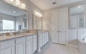 Een bad/douchecombinatie, een haardroger, handdoeken