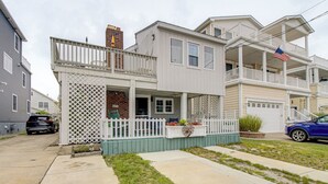 Ein zweistöckiges Wohnhaus mit Veranda, kleinem Garten und einer sichtbaren amerikanischen Flagge.