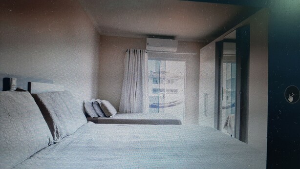 A room with a bed, a small table, and a window.