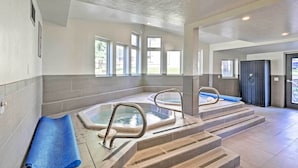Un área de spa con dos jacuzzis, un tapete azul y una escalera que lleva a los jacuzzis.