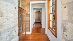 Un couloir doté de planchers en bois, de murs en pierre et d’une armoire en bois.