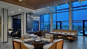 A modern lounge area with sofas, a coffee table, and a fireplace. - AC Hotel by Marriott Austin Hill Country (Austin)