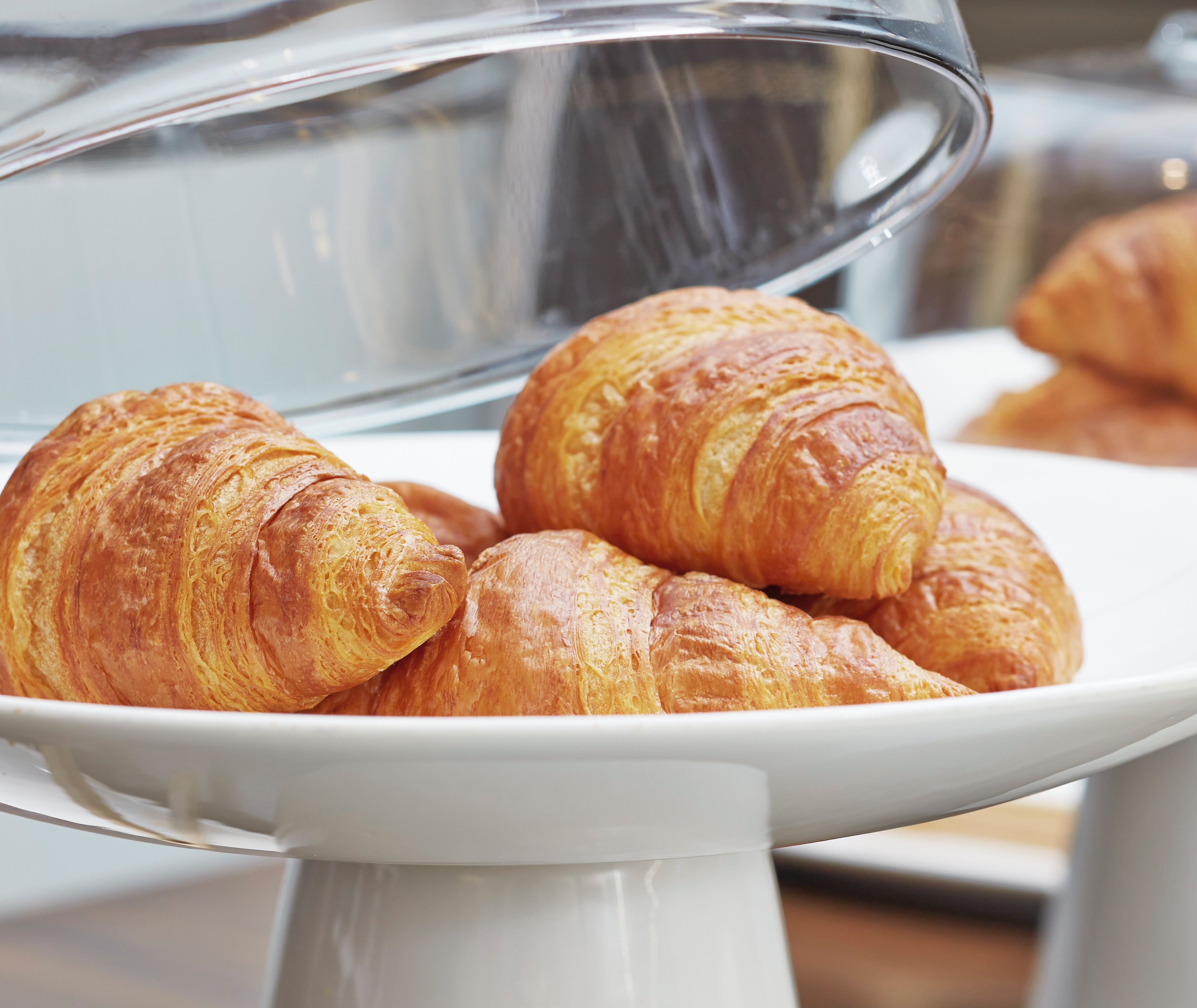 A display of croissants on a white stand.