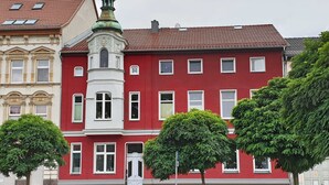 A red building with a white tower and multiple windows. - Ferienwohnung Leuchtturm 29a - Ferienwohnung (Guben)