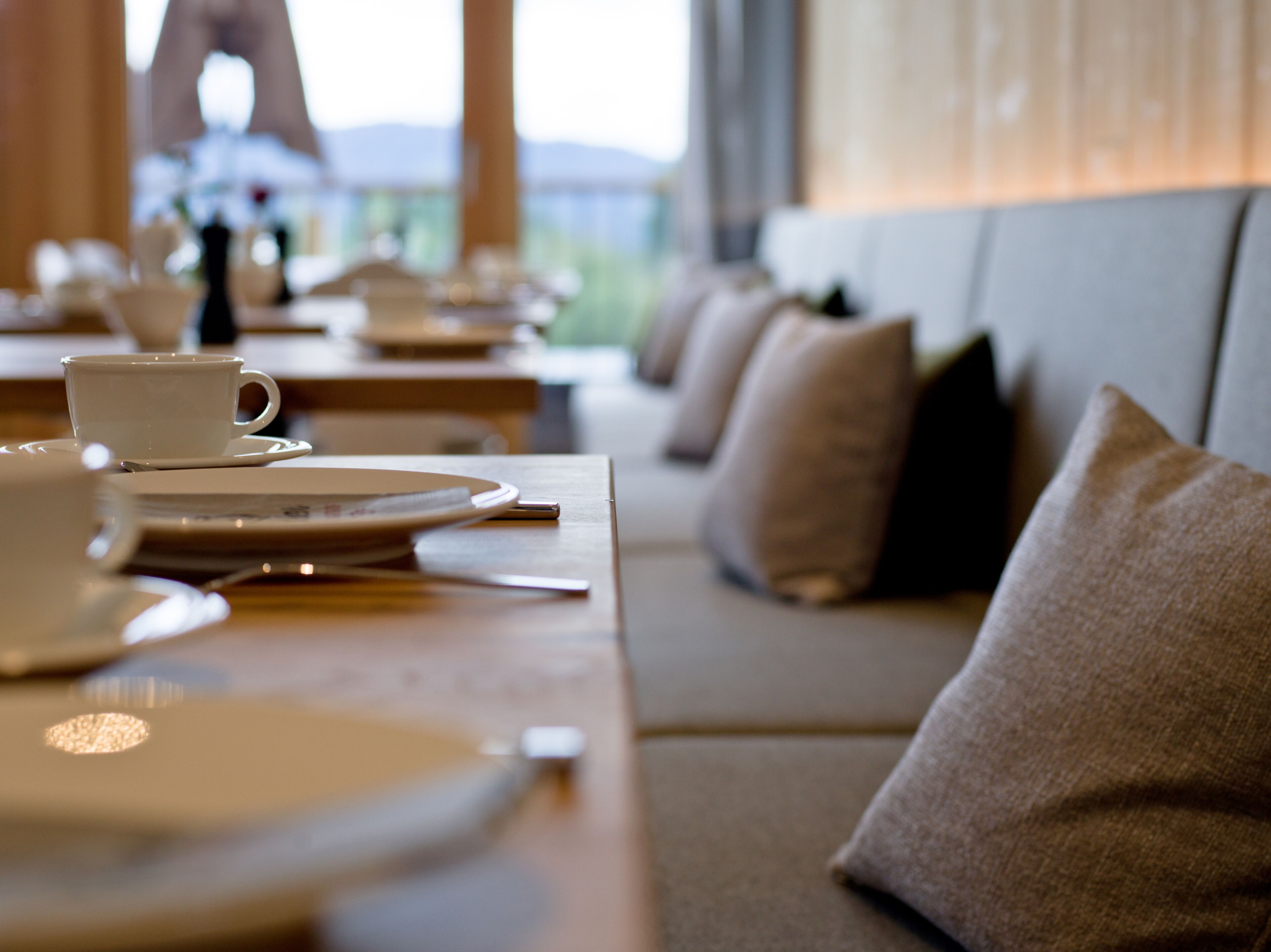 A dining area with tables set for meals, including plates, cups, and cutlery.
