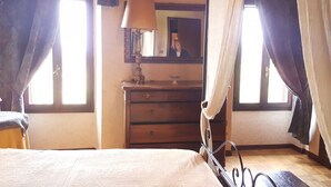 A bedroom with a bed, a dresser, a mirror, and a window with curtains. - AMAZING HISTORICAL COUNTRY HOUSE (Pozzolengo)