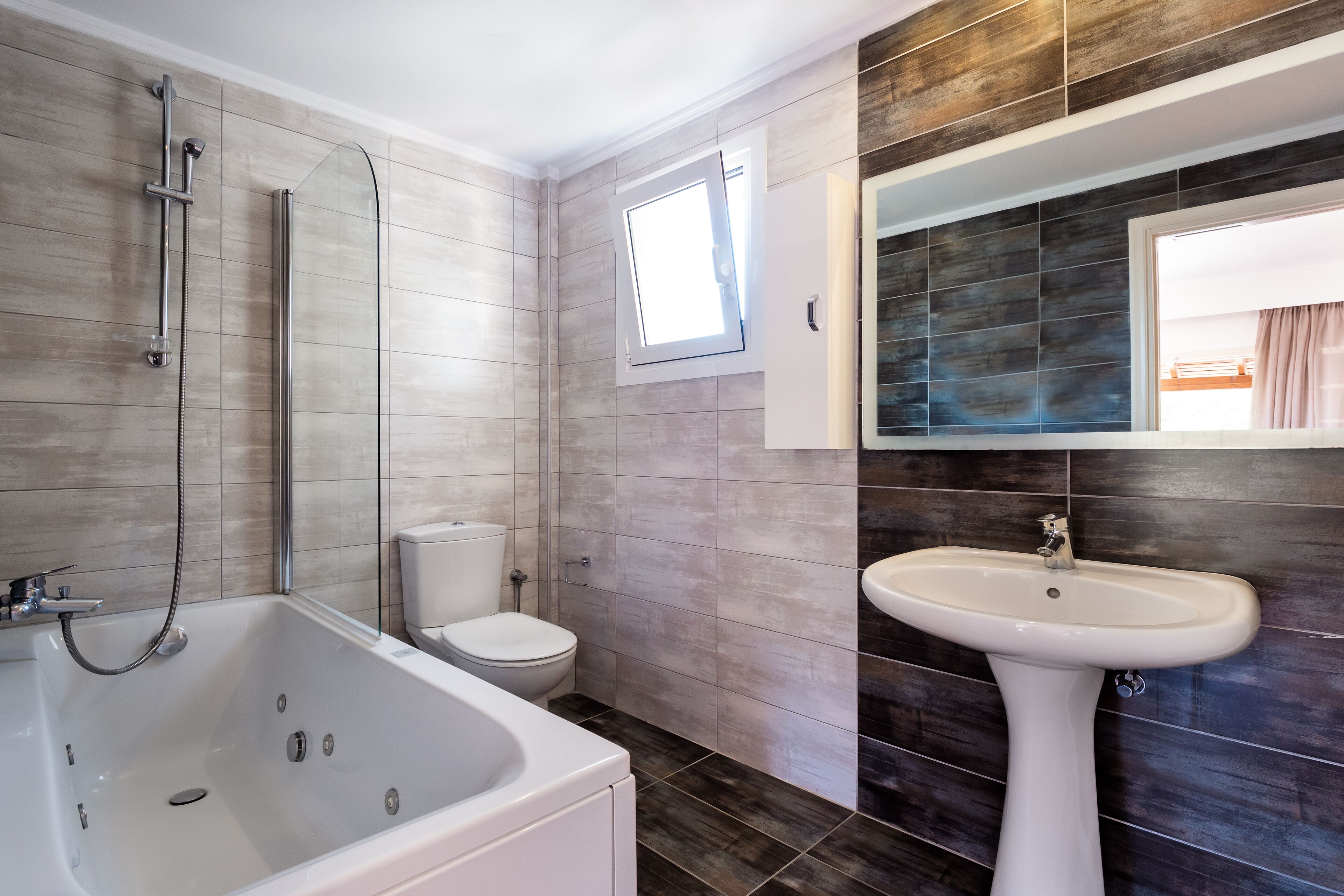 Une salle de bain moderne avec une baignoire, des toilettes et un lavabo.