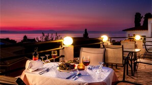Une table dressée pour le dîner, avec vue sur les montagnes et un ciel étoilé.