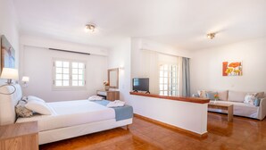 Une chambre d’hôtel moderne équipée d’un lit, d’une télévision, d’un bureau et d’un canapé.