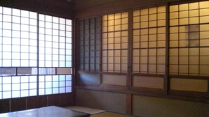 A traditional Japanese room with tatami flooring, a low table, and sliding doors with grid patterns. - Marina bay Numazu (Numazu)