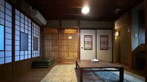 A traditional Japanese room with tatami flooring, a low wooden table, and sliding doors with decorative patterns. - Marina bay Numazu (Numazu)