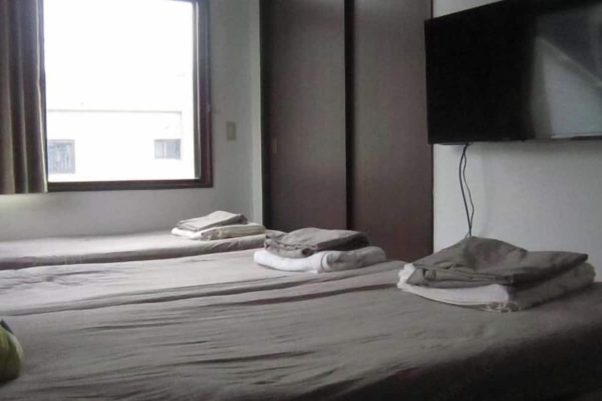 Tabla de planchar con plancha y ropa de cama