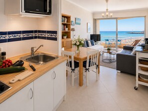 Una cocina moderna con un fregadero, un microondas y una zona de comedor con mesa y sillas.