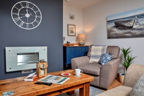Relax in this inviting space with a comfortable sofa, fireplace, and beautiful artwork.