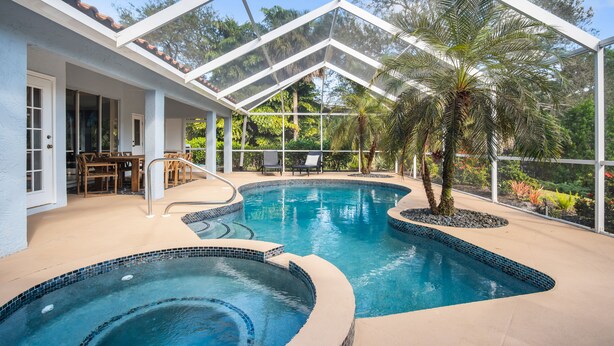 An indoor swimming pool with a glass ceiling, surrounded by palm trees and a patio area with outdoor furniture. - /\ Amazing Location/\ 10 mins away from beach and Mercato/ New Diamond in Naples (Naples)