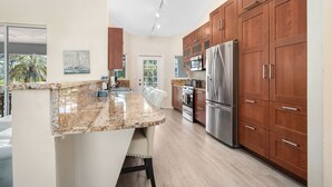 A modern kitchen with granite countertops, stainless steel appliances, and wooden cabinets. - /\ Amazing Location/\ 10 mins away from beach and Mercato/ New Diamond in Naples (Naples)