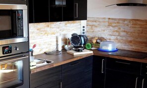 A kitchen with a microwave, oven, and toaster.
