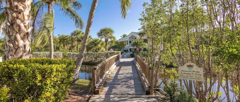 A wooden bridge leading to a house with a sign indicating no swimming or diving.