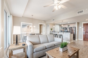 A modern living room with a sofa, coffee table, and a dining area with chairs.