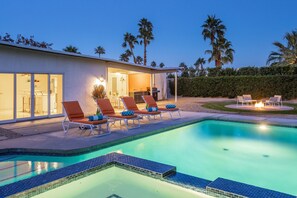 Une maison moderne dotée d’une piscine, d’un espace extérieur aménagé et d’un intérieur bien éclairé.