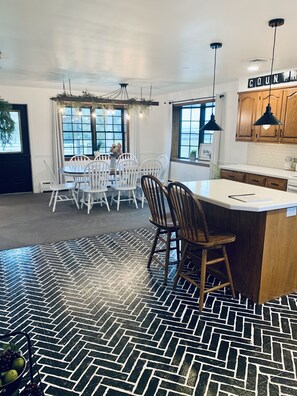 Une cuisine moderne avec des meubles en bois, un îlot central et des luminaires suspendus.