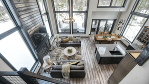 Un amplio salón con una chimenea grande, una mesa de comedor y varias opciones de asiento.