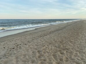 A beach with a wide sandy shore and gentle waves. - Seaclusion Near Bethany Beach (Ocean View)