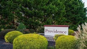 A sign reading "Providence" surrounded by well-maintained shrubbery and trees. - Seaclusion Near Bethany Beach (Ocean View)