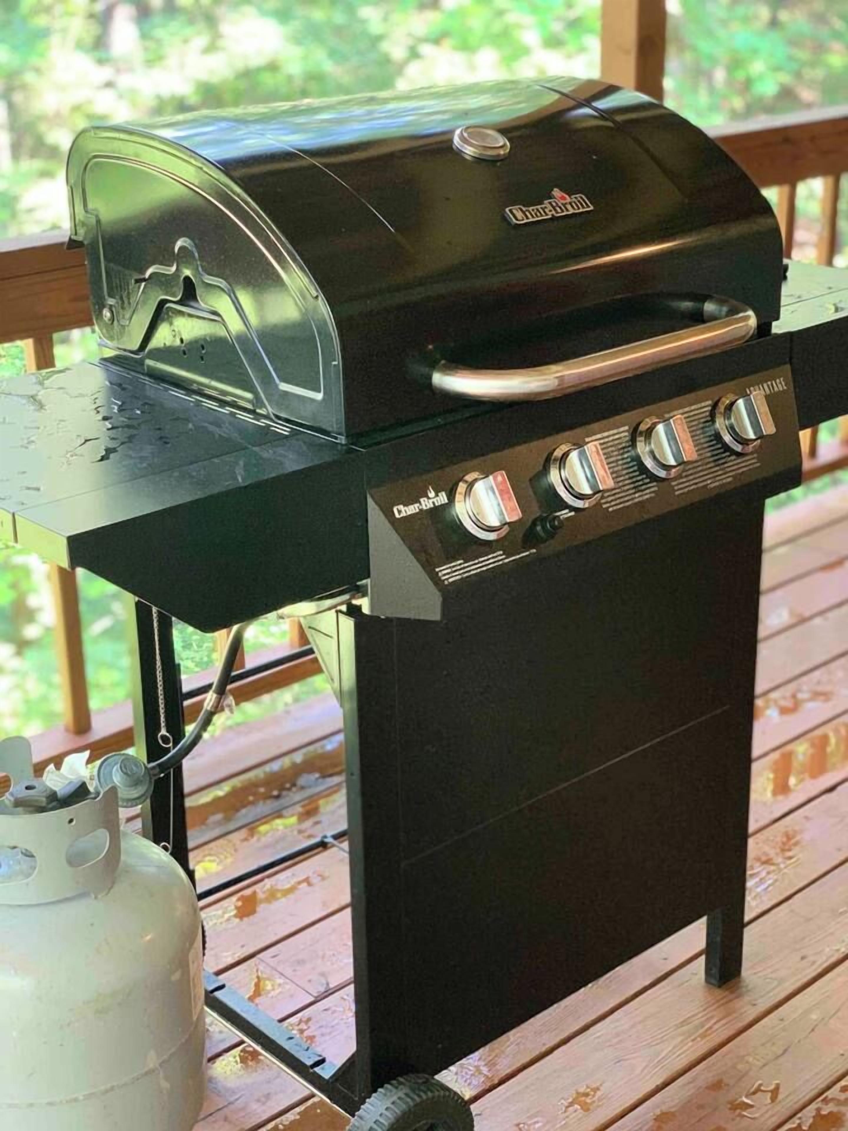Una parrilla de gas Char-Broil con cuatro quemadores, una abertura lateral y una tapa.
