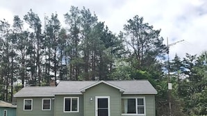 A single-story house with a front door, two windows on the first floor, and a small porch. - Comfy Cottage to escape the crowds (Goetzville)