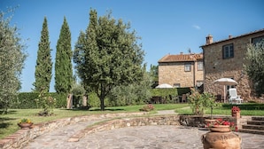 Un sendero de piedra que conduce a un edificio de piedra con techo de tejas.