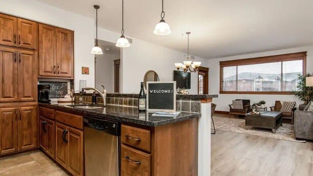 Una cucina moderna con mobili in legno, un'isola centrale e luci a sospensione.