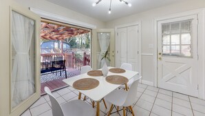 A dining area with a white table, four chairs, and woven placemats. - Atlanta Luxury Home 1 mi from The Battery Sleeps 8 (Smyrna)