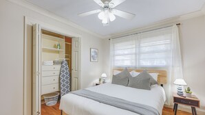 A bedroom with a bed, bedside tables, a ceiling fan, a window with curtains, and a wardrobe. - Atlanta Luxury Home 1 mi from The Battery Sleeps 8 (Smyrna)