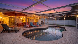 An outdoor pool area with lounge chairs and a covered patio.