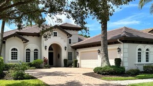 A two-story house with a driveway leading to a garage.