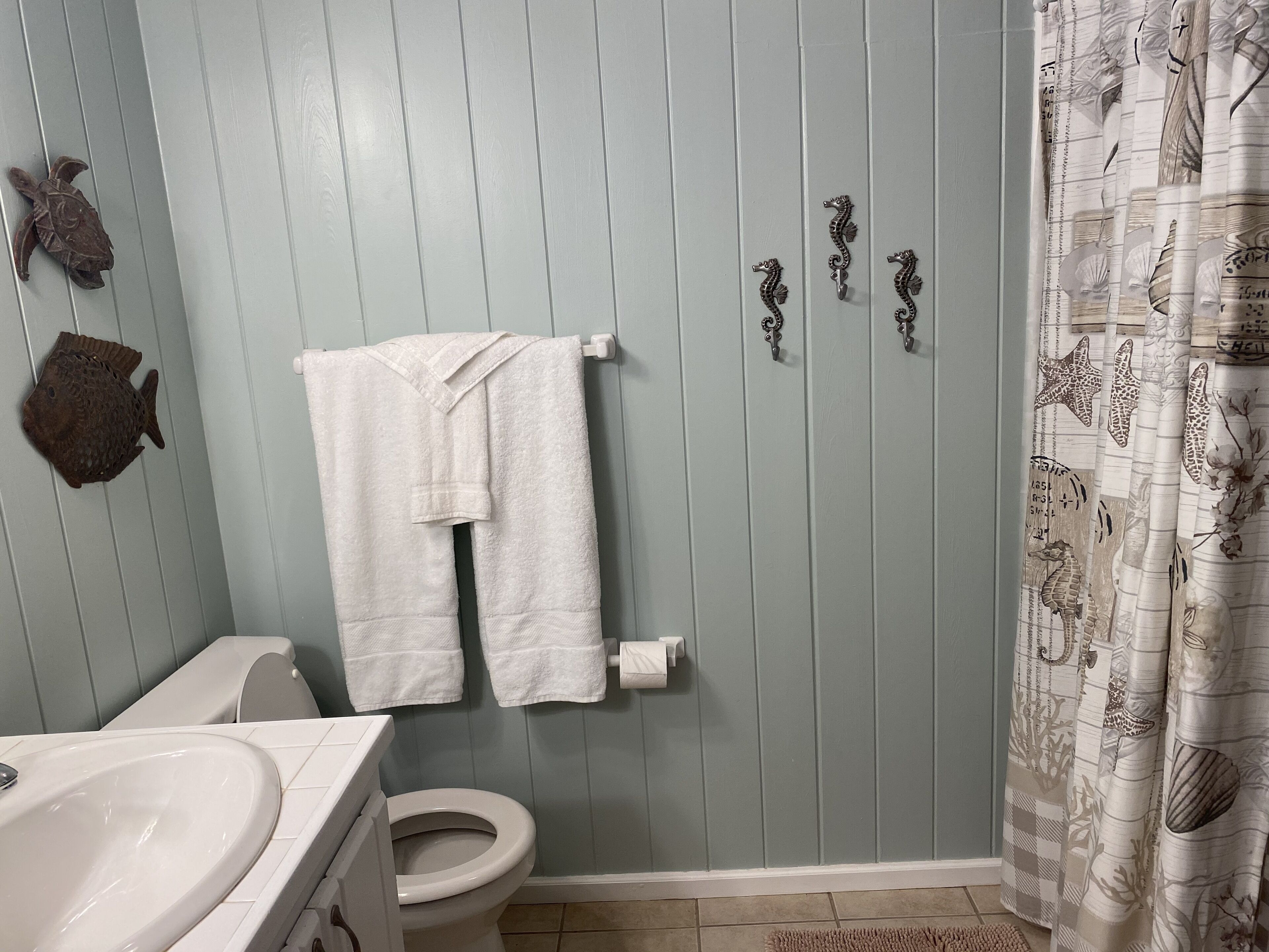 A bathroom with a toilet, sink, and towel rack.