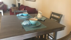 Una tavola apparecchiata con ciotole e piatti blu, un boccale bianco e un tovagliolo blu.