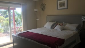 Una camera da letto con un letto, una finestra, una porta e un quadro appeso al muro.