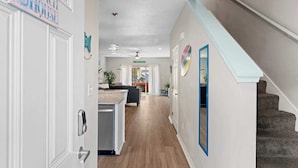 Un interior moderno con cocina, comedor y una escalera.