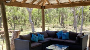 An outdoor seating area with a wooden deck and a covered section with a metal roof. - La Block Yallingup simply the best! (Yallingup)