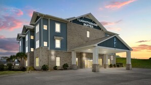 Un hôtel avec une enseigne indiquant « Lighthouse Suites » et une entrée abritée.